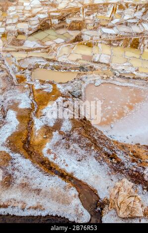 Primo piano del salnitro costruito in una valle in un giorno nuvoloso di Maras in Perù Foto Stock