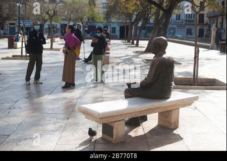 Persone che indossano maschere facciali come precauzione contro la diffusione di Coronavirus stand di fronte alla statua dell'artista spagnolo Pablo Picasso nel centro città.spagnolo primo ministro Pedro Sánchez ha dichiarato lo stato di emergenza in Spagna a causa dell'epidemia di Covid-19, Dopo l'aumento del numero di casi di persone infette da Covid-19 nel paese. Le autorità spagnole hanno chiuso musei e monumenti per controllare l'espansione dell'epidemia di Covid-19. La città di Malaga è la prima in Andalusia con il maggior numero di persone infettate. Foto Stock