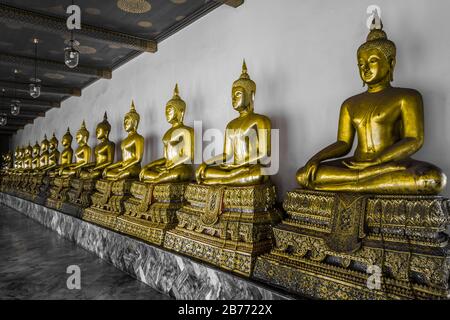 Fila di statue buddiste dorate in un tempio a Bangkok, Thailandia. Foto d'archivio gratuite. Foto Stock