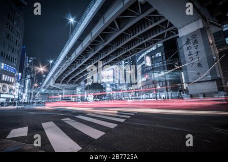 Esposizione notturna di un passaggio pedonale sotto un'autostrada sopraelevata a est di Umeda a Osaka, Giappone. Foto Stock