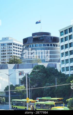 Il Beehive, il parlamento neozelandese di Wellington, vola la bandiera a metà albero nel primo anniversario della sparatoria della moschea di Christchurch del 2019. Foto Stock