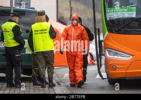 Kudowa Zdroj, Polonia. 13 Marzo 2020. Gli agenti di polizia di frontiera polacchi in tute protettive effettuano controlli medici e misurazioni della temperatura di conducenti e passeggeri provenienti dall'estero al valico di frontiera tra Polonia e Repubblica Ceca, il 13 marzo 2020, Nachod-Kudowa Zdroj, a causa delle preoccupazioni circa la diffusione del nuovo coronavirus. Credit: David Tanecek/Ctk Photo/Alamy Live News Foto Stock