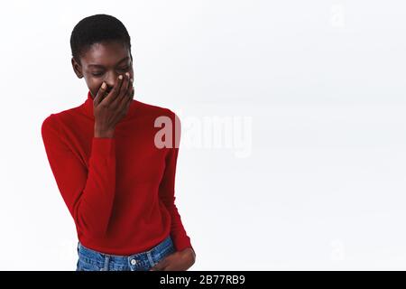 Felice attraente african american donna cant tenere ridere, provare atto fresco, coprire il sorriso con la mano come ridere, guardare in basso, concetto di emozioni, stile di vita Foto Stock