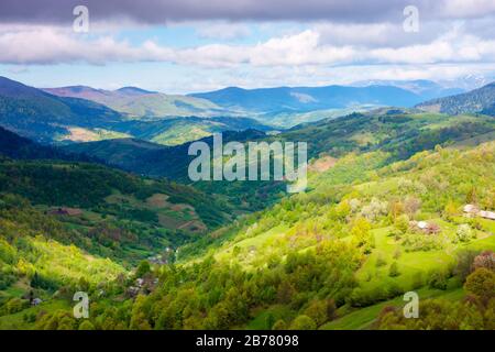 paesaggio rurale in montagna. luce con pannolini sulle colline boscose. splendido paesaggio naturale in primavera. bel tempo con nuvole Foto Stock