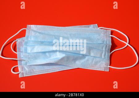 maschera medica con cuscinetti in gomma sul pavimento rosso come concetto di protezione, protezione antivirus con maschera clinica per bocca e naso Foto Stock