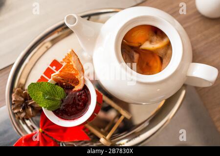Tè marocchino con arancia e limone in una teiera con marmellata di lamponi e spezie Foto Stock