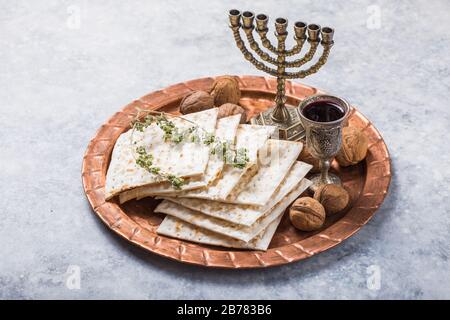 Pasqua, la festa del pane Azzimo, pane di Matzah e bicchieri di vino rosso sul piatto rotondo lucido di metallo Foto Stock