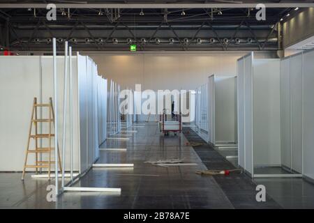 Vienna, Austria. 14 Marzo 2020. I lavoratori sono occupati all'interno della Messe Vienna, una grande sala espositiva che si sta trasformando in un ospedale temporaneo per pazienti affetti da coronavirus a Vienna, Austria, 14 marzo 2020. Secondo i media austriaci, la sala espositiva Messe Vienna è in preparazione per un grande ospedale e la prossima settimana saranno disponibili 880 posti letto. La struttura è destinata a pazienti con un decorso lieve della malattia, ma che non possono essere curati a casa. Credit: Guo Chen/Xinhua/Alamy Live News Foto Stock