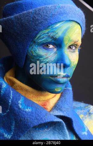 Pittura vivente - donna completamente ricoperta di spessa vernice, progetto di body art ispirato alla pittura di Starry Night Van Gogh. Indossare abiti in feltro Foto Stock