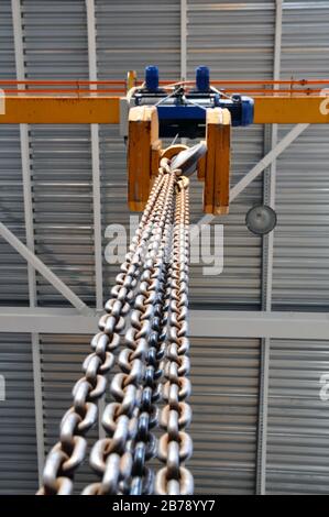 Paranco a catena. Gancio industriale appeso alla catena dell'aspo. Industriale Foto Stock
