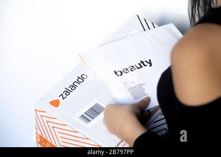 Poznan, Polonia - 14 marzo 2020: Donna in possesso di una scatola Zalando con gli articoli ordinati dal negozio online. Foto Stock