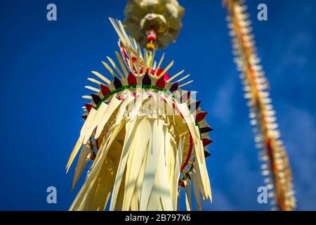 Penjors balinesi tradizionali sulle strade di Bali, Indonesia. Alti pali di bambù con decorazione sono ambientato in onore degli dei indù sulla festa religiosa Foto Stock