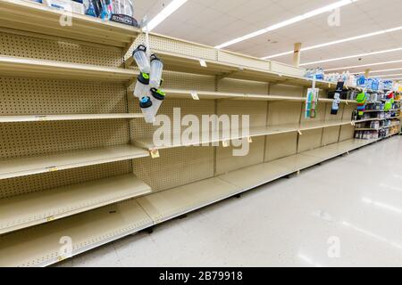 Scaffali vuoti nel corridoio dell'acqua in bottiglia in un negozio di alimentari del supermercato come coronavirus causa paura e panico orizzontale Foto Stock