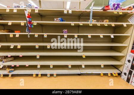 Scaffali quasi vuoti in un supermercato negozio di alimentari nel pane isola come coronavirus causa paura e panico orizzontale Foto Stock