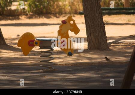 Primo piano di una sedia a dondolo a forma di cavallo in un parco giochi pubblico per bambini in città Foto Stock