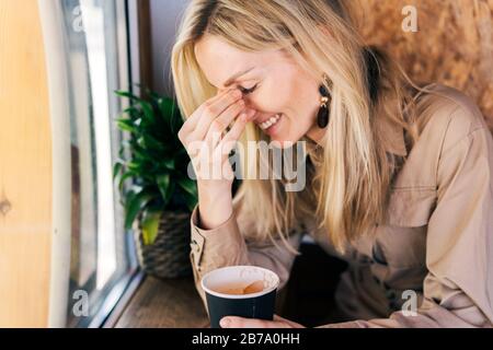 emozioni donna che ride in un bar Foto Stock