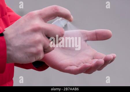 Primo piano della mano maschile con spray antisettico o antibatterico. Disinfezione delle mani. Concetto di assistenza sanitaria durante un'epidemia o pandemica Foto Stock