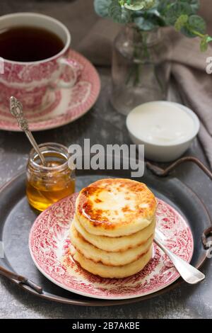 Pancake di formaggio casolare, sciroppi fatti in casa con miele e panna acida. Foto Stock