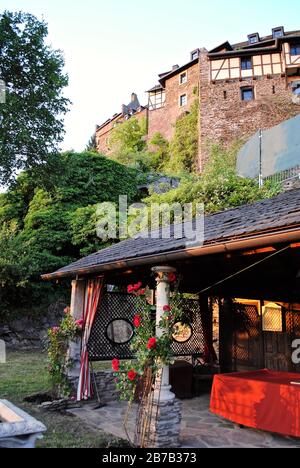 Burghotel Castle Hotel Auf Schönburg (Auf Schoenburg) a Oberwesel, Germania sopra la valle del fiume Reno superiore (Rhein). Giardini all'aperto con rose rosse. Foto Stock