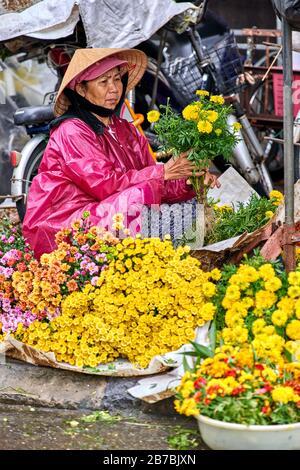 Da Nang, Vietnam-05 Dicembre 2014:venditore non identificato in un mercato. Venditori di fiori in Vietnam. Vita in Vietnam Foto Stock