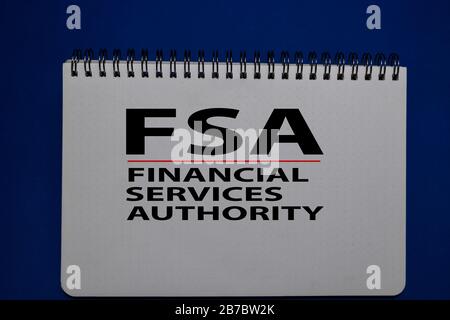 FSA - Acronimo di Financial Services Authority (autorità di servizi finanziari) scrivere su un libro isolato su Office Desk. Foto Stock
