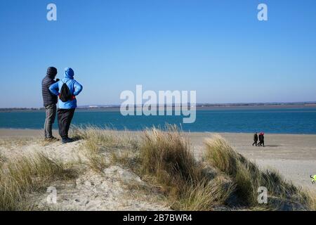 Persone che guardano alla spiaggia durante l'inverno Foto Stock