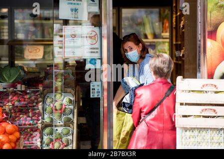 Granada, Spagna. 14 Marzo 2020. Una donna che indossa una maschera facciale come precauzione contro la diffusione del Coronavirus visto in un negozio di frutta.il primo ministro spagnolo Pedro Sánchez ha dichiarato lo stato di emergenza in Spagna a causa dell'epidemia di Covid-19, dopo l'aumento del numero di casi di persone infettate con Covid-19 nel paese. Le autorità spagnole hanno chiuso musei e monumenti per controllare l'espansione dell'epidemia di Covid-19. La città di Malaga è la prima in Andalusia con il maggior numero di persone Infected Credit: Sopa Images Limited/Alamy Live News Foto Stock