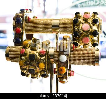 Un assortimento di grandi bracciali in ottone etnico beweled su un'elegante esposizione in vetrata boutique nel centro storico di Scottsdale, Arizona, Stati Uniti Foto Stock