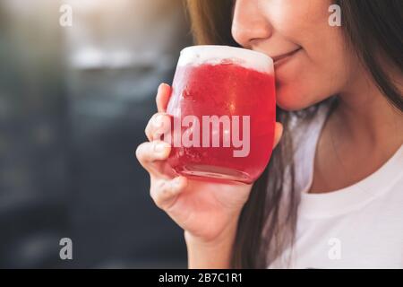 Immagine closeup di una donna asiatica godere di bere soda di fragola con sensazione di felicità Foto Stock