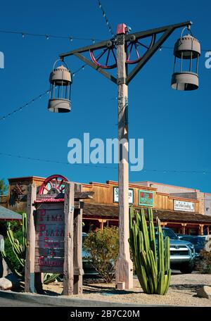 Un tema del Vecchio West con vecchie lampade da strada lanterna e parti di ruote del carro con segnaletica per i negozi e le gallerie di Pima Plaza nella città vecchia Scottsdale, Arizona Foto Stock