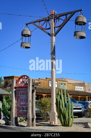 Un tema del Vecchio West con vecchie lampade da strada lanterna e parti di ruote del carro con segnaletica per i negozi e le gallerie di Pima Plaza nella città vecchia Scottsdale, Arizona Foto Stock