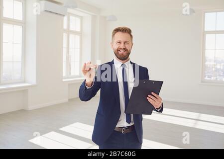 Agente immobiliare allegro con chiave in nuovo appartamento Foto Stock