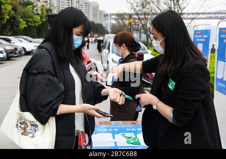 Chongqing, Chongqing Cinese. 14 Marzo 2020. Un cliente ha la sua temperatura corporea controllata prima di entrare in un ristorante hot pot nel distretto di Jiangbei, a sud-ovest della Cina Chongqing, 14 marzo 2020. Con misure di prevenzione contro il nuovo coronavirus, tra cui la limitazione dell'accesso e il controllo delle temperature del corpo, molti ristoranti nel quartiere riaperto in modo ordinato negli ultimi giorni. Credit: Wang Quanchao/Xinhua/Alamy Live News Foto Stock