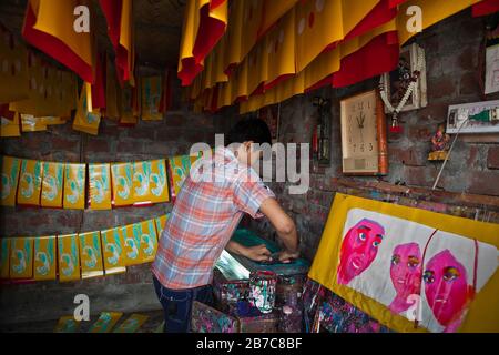 Joy, figlio di Proshanto Kumar Das e nipote di Raj Kumar Das, meglio conosciuto come RK Das, uno degli artisti di rickshaw di prima generazione in Bangladesh, è occupato nello studio del padre nella capitale Dhaka, il 3 maggio 2012. L'arte del risciò è una forma di arte pop che descrive la nostra cultura urbana e il folklore del Bangladesh. I rickshaws furono introdotti per la prima volta in Bangladesh negli anni trenta dal Giappone, dove i veicoli a tre ruote erano noti come 'ningaku'. L'idea di decorare i contrasti a motore delle gambe ha preso il via in Bangladesh negli anni '50 con la tradizione seguendo lo stile semplice ma colorato poi utilizzato dalla pittura Foto Stock