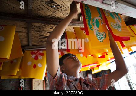 Joy, figlio di Proshanto Kumar Das e nipote di Raj Kumar Das, meglio conosciuto come RK Das, uno degli artisti di rickshaw di prima generazione in Bangladesh, è occupato nello studio del padre nella capitale Dhaka, il 3 maggio 2012. L'arte del risciò è una forma di arte pop che descrive la nostra cultura urbana e il folklore del Bangladesh. I rickshaws furono introdotti per la prima volta in Bangladesh negli anni trenta dal Giappone, dove i veicoli a tre ruote erano noti come 'ningaku'. L'idea di decorare i contrasti a motore delle gambe ha preso il via in Bangladesh negli anni '50 con la tradizione seguendo lo stile semplice ma colorato poi utilizzato dalla pittura Foto Stock