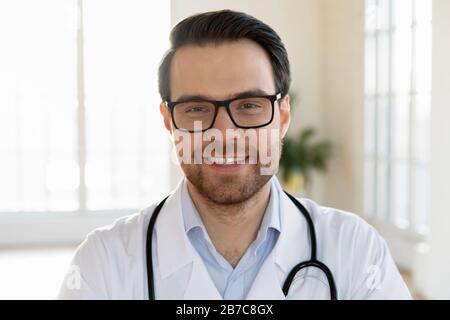 Testa colpo da vicino sorridente medico terapeuta in occhiali. Foto Stock
