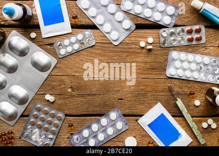 pillole mediche su uno sfondo di legno e spazio per il testo Foto Stock