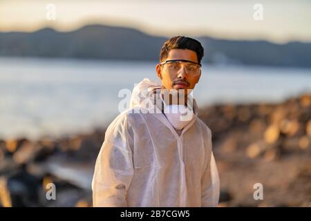 Scienziato o lavoratore sanitario sicuro in piedi sulla spiaggia Foto Stock
