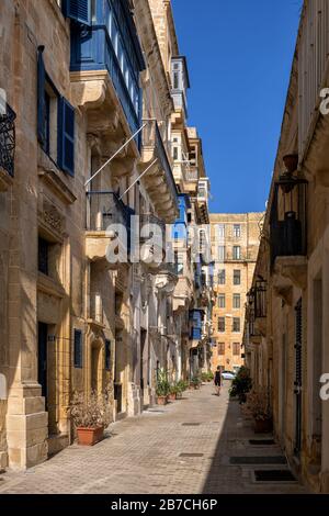 Strada e tradizionali case maltesi nella città vecchia di Valletta a Malta Foto Stock