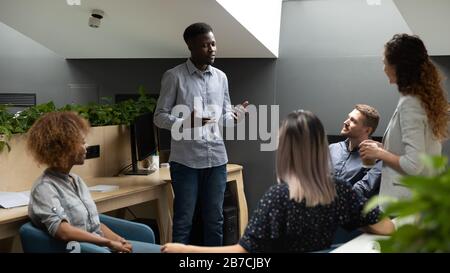 Il team leader afro-americano tiene un incontro di pianificazione con diversi dipendenti Foto Stock