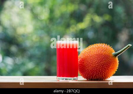 Baby Jackfruit, frutta GAC con succo di jackfruit su sfondo sfocato. Bevanda e concetto sano. Foto Stock