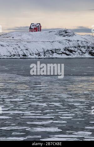 Ghiaccio sulla Trinity Bay con una casa imponente lontano, in English Harbour di Terranova, Canada [Nessun rilascio di proprietà; disponibile per la licenza editoriale o Foto Stock