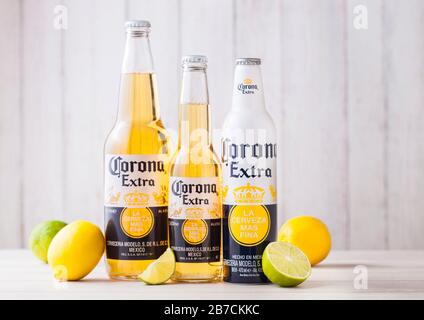 LONDON, Regno Unito - 27 Aprile 2018: bottiglie di Corona Extra birra su sfondo di legno con freschi Limoni e limette . Corona, prodotta dal Grupo Modelo. Foto Stock