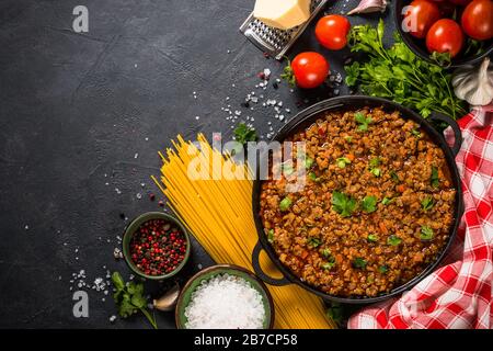 sause bolognese in piastra di ferro a tavola nera. Foto Stock