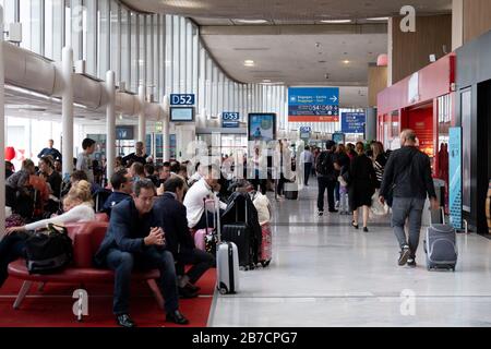 Porte di partenza affollate al terminal dell'aeroporto Charles de Gaulle di Parigi, Francia, Europa Foto Stock