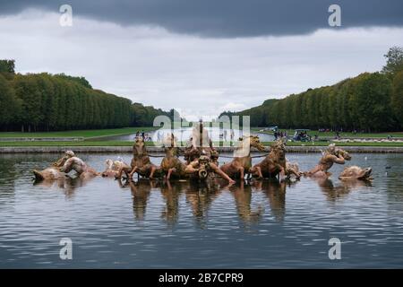 Lo Stagno di Apollon con la scultura dorata del carro del Dio Sole Apollo che emerge dall'acqua ai Giardini del Palazzo di Versailles, Francia Foto Stock