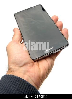 Mano che tiene lo smartphone Huawei Mate 9 tagliata su uno sfondo bianco Foto Stock