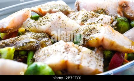 Pesce sano al forno con verdure, filetto di merluzzo fritto con lattuga e verdure da vicino, fuoco selettivo, spezie cavoli di bruxelles, vegetariano Foto Stock