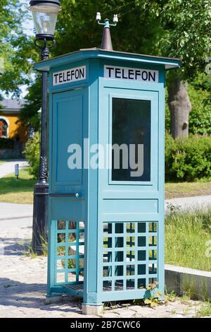 Cabina telefonica in legno antico con la parola telefono scritta in svedese Foto Stock