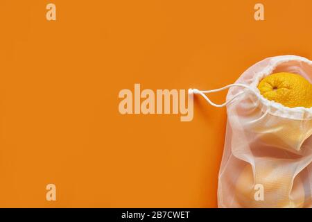 Borsa con cordoncino e arancio, piccolo sacco ecologico in tessuto di cotone naturale. Spazio di copia Foto Stock